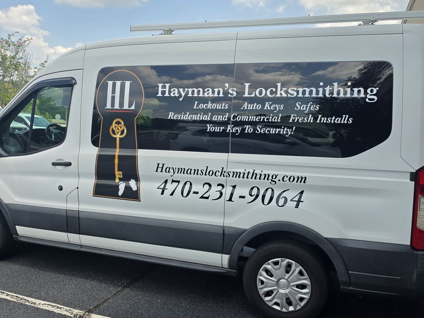 Driver side of the Hayman’s Locksmithing van listing lockouts, auto keys, safes, residential and commercial