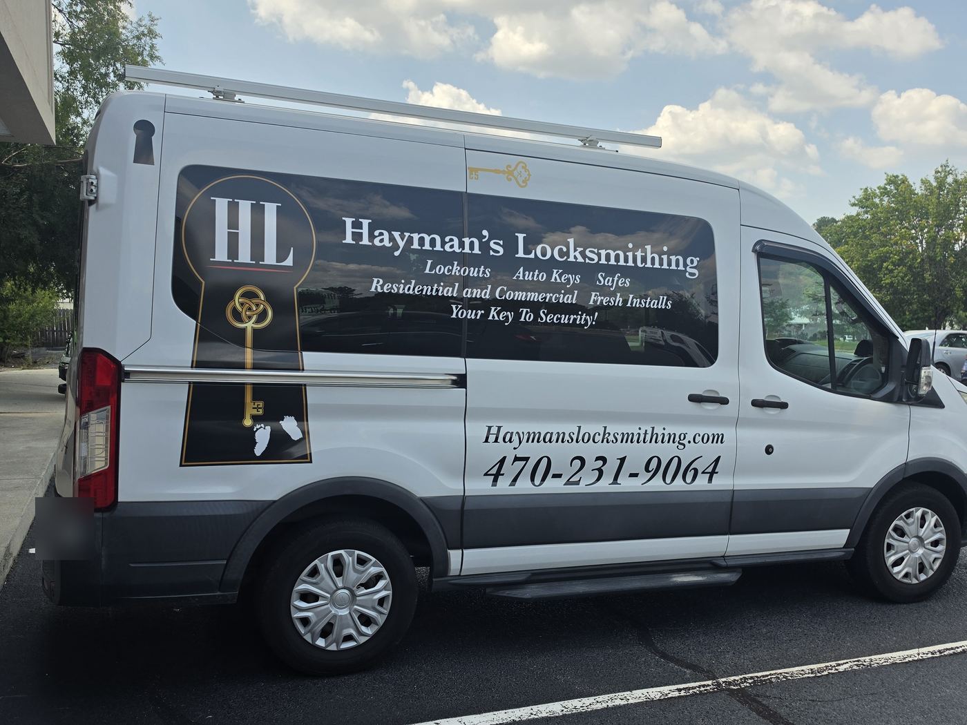 Hayman’s Locksmithing white Ford Transit work van with HL keyhole logo and phone number 470-231-9064